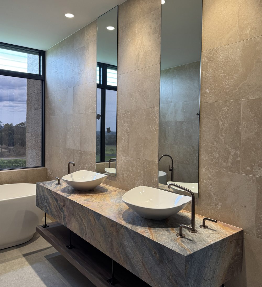 Completed Monado project — stone bathroom with twin basins